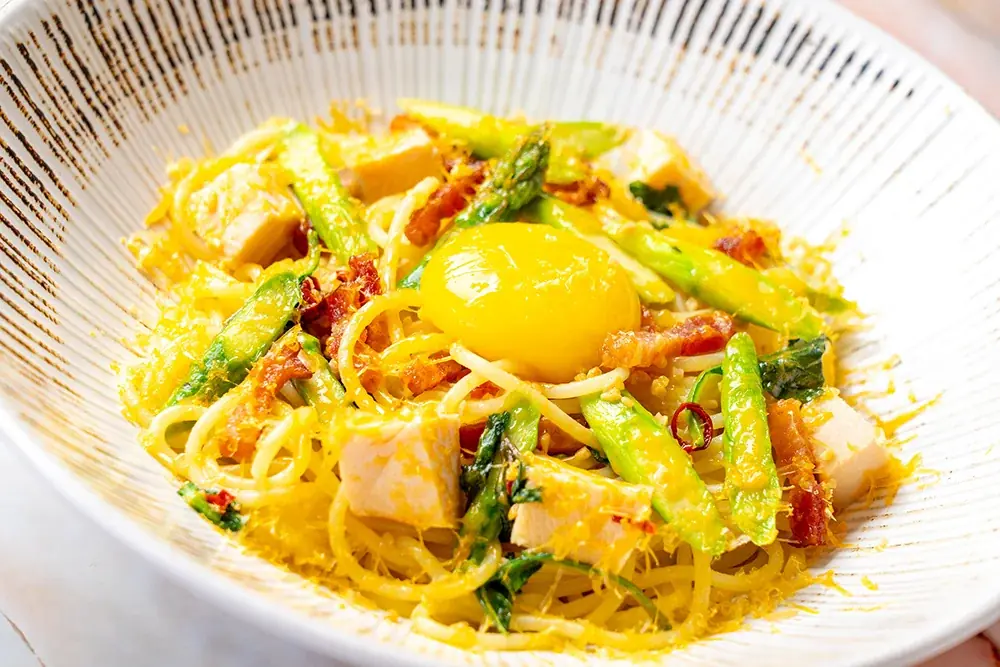 【期間限定】北海道産アスパラを贅沢に！北海道生パスタ専門店「麦と卵」不動の人気No.1メニューが進化。黄金色に輝く新作パスタが4月21日から期間限定登場。ミモレットとバジルが織りなす極上の香りと彩り。 画像 2