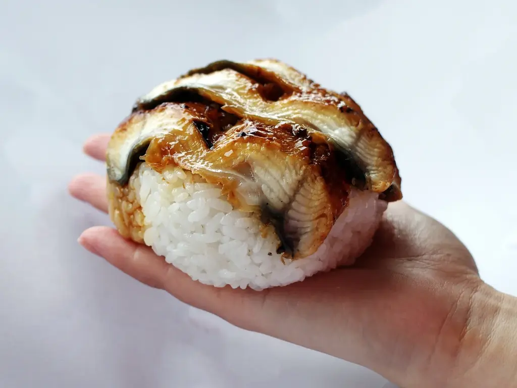 手のひらからはみ出す！角上魚類の「角上うなぎおにぎり」登場。土用の丑の日に向けてたっぷりのうなぎ蒲焼きを使用した、圧倒的な大きさと具材の贅沢さにこだわったおにぎり第三弾！ 画像 2